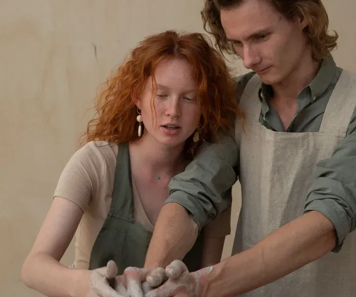 Artisans d'art façonnant ensemble une céramique à l'atelier